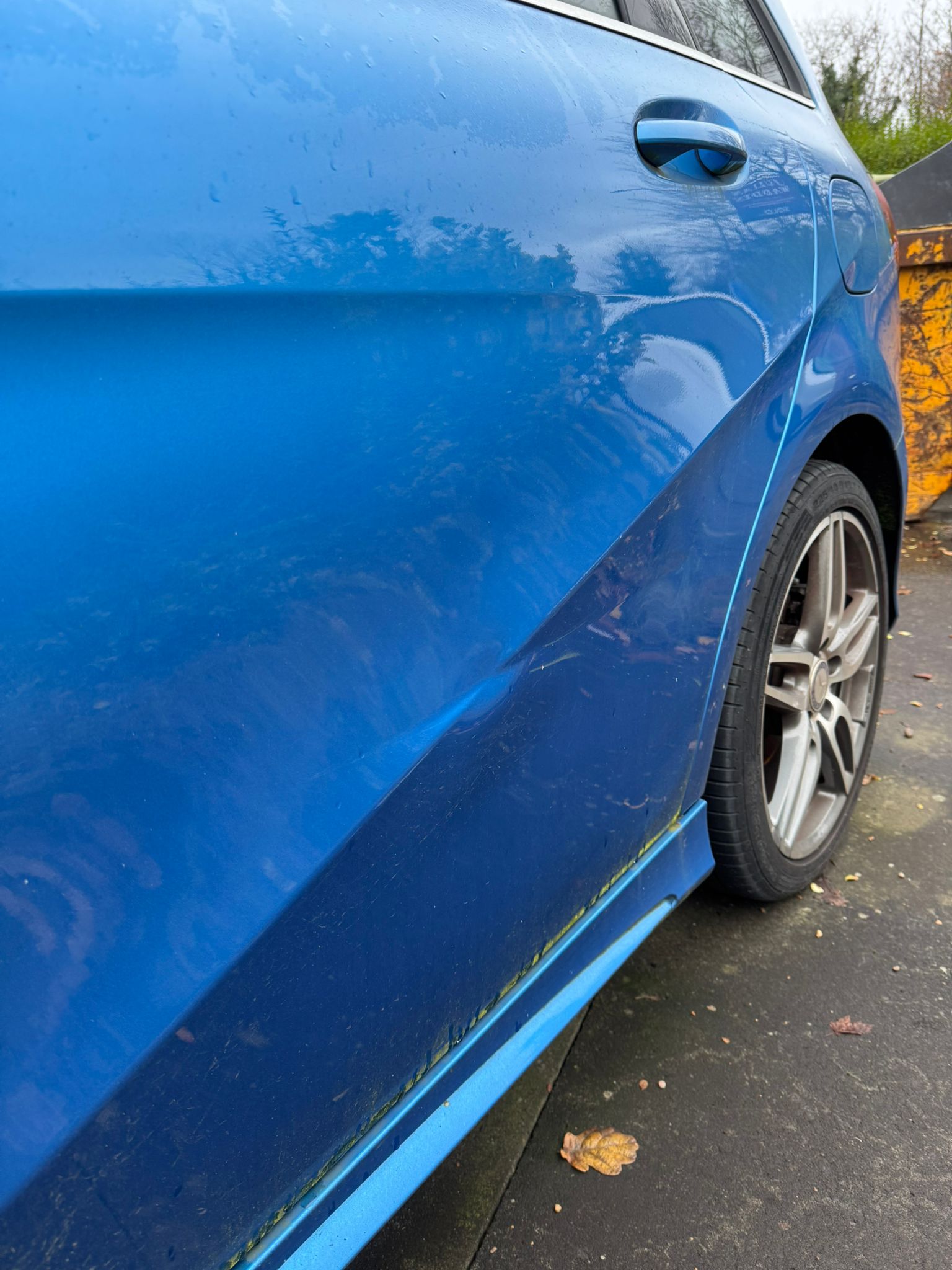 Blue vehicle side panel during SMART repair